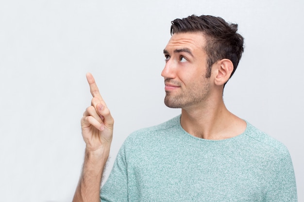 Thoughtful Attractive Man Pointing Upwards