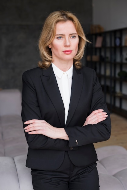 Thoughtful business woman standing with crossed arms