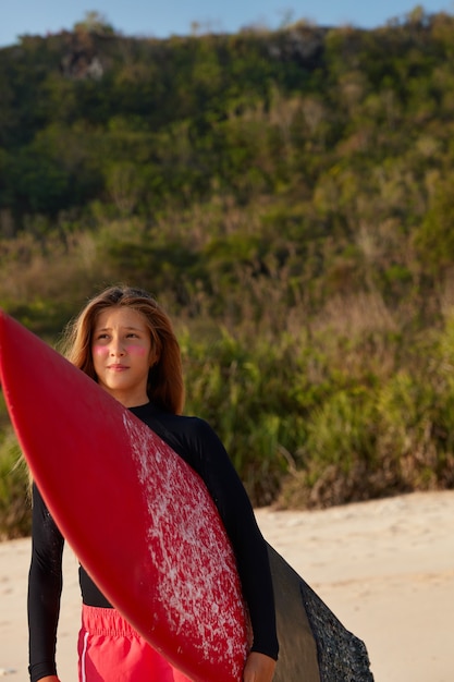 Thoughtful contemplative woman carries longboard