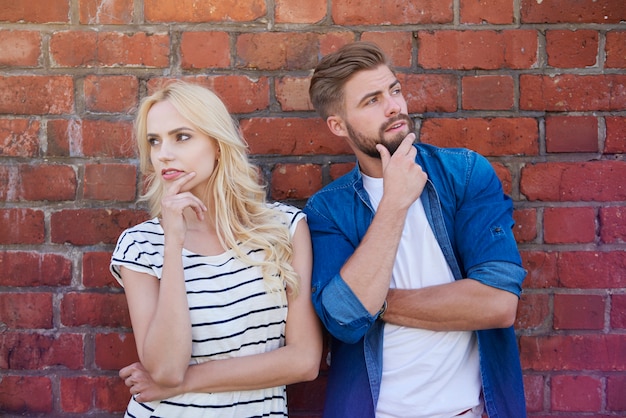 Thoughtful couple and the brick wall