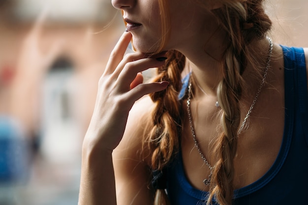 Free Photo thoughtful girl in a fitness suit poses before a window in a gym