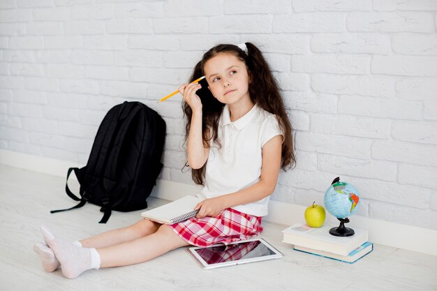 Thoughtful girl with notepad