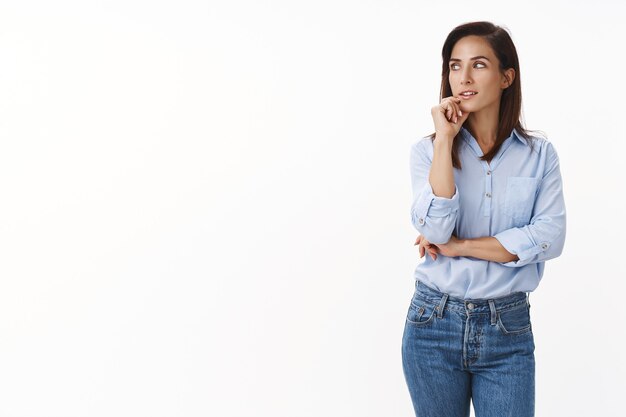 Thoughtful intrigued good-looking caucasian adult lady entrepreneur have interesting thought, look left interested pondering, touch chin, searching inspiration, have idea mind, stand white wall