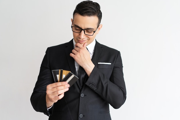 Free photo thoughtful mixed race businessman looking at credit cards.