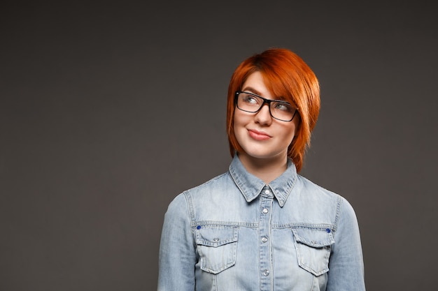 Free photo thoughtful redhead woman over black wall