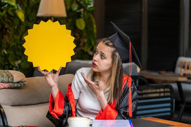 Free photo thoughtful student holding idea board and looking at it