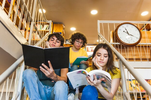 Thoughtful teenagers reading on steps