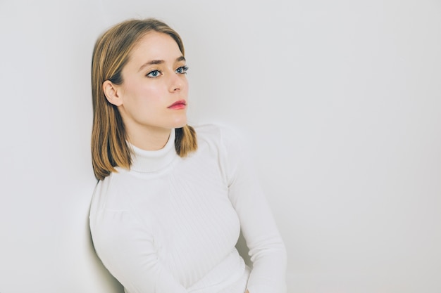 Thoughtful woman sitting at wall