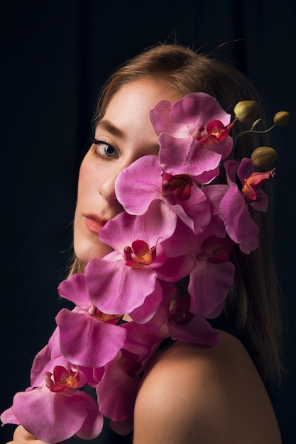 Thoughtful woman with bright pink flower