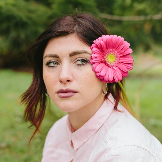 Thoughtful woman with flower in hair