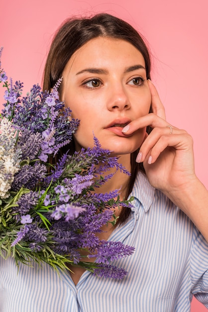 Thoughtful woman with flowers bouquet 