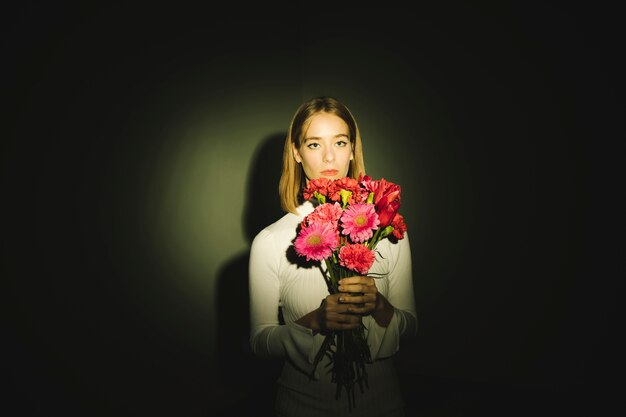 Thoughtful woman with flowers bouquet 