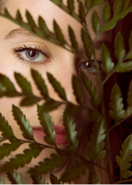 Free Photo thoughtful woman with green plant branch