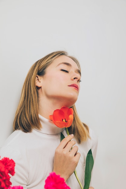 Thoughtful woman with tulip flower