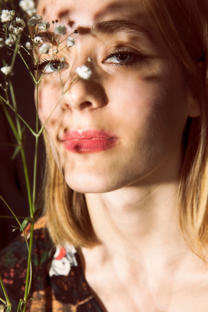 Free Photo thoughtful woman with white flower branch