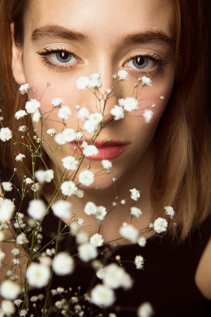 Free Photo thoughtful woman with white flowers