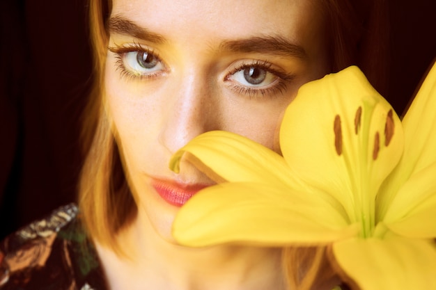 Free photo thoughtful woman with yellow flower