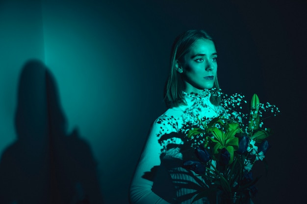 Thoughtful young woman with flowers 