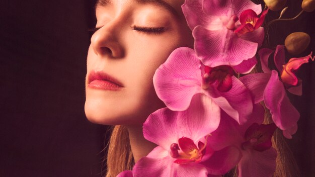 Thoughtful young woman with pink flower