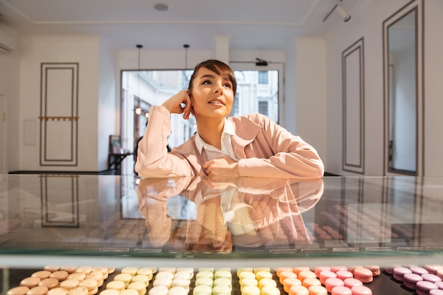 Free Photo thoughtful young young woman choosing pastries