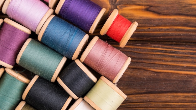 Free photo thread spools on wood background