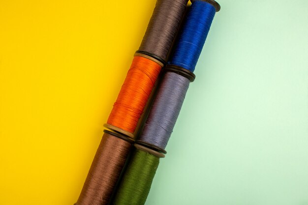 Threads multicolored for sewing on a yellow-green floor