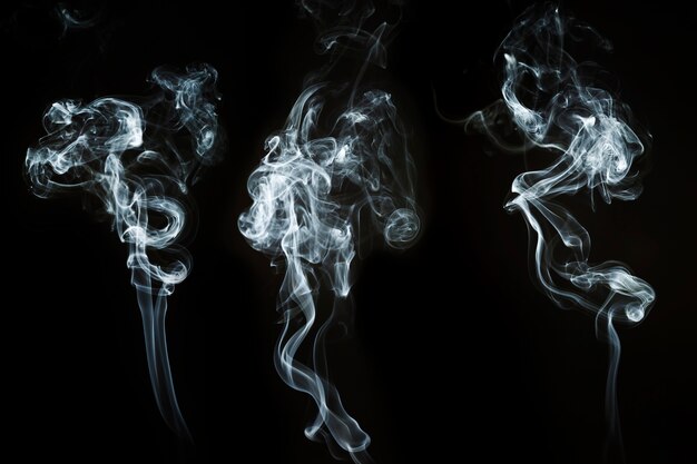 Three abstract shapes of white smoke