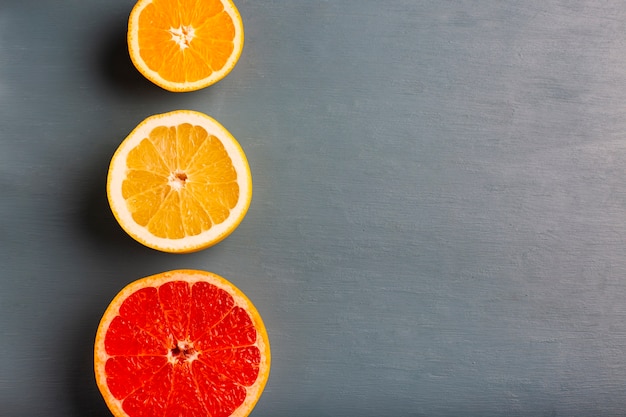 Three aligned citrusses on table with copy-space