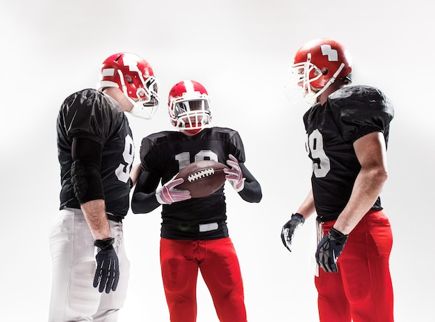 Free photo the three american football players posing with ball