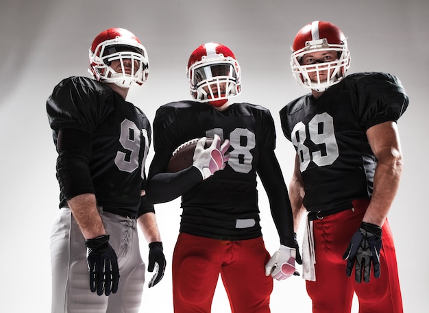 Free photo the three american football players posing with ball