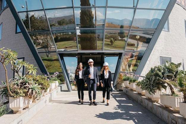 Free photo three architects in front of modern building