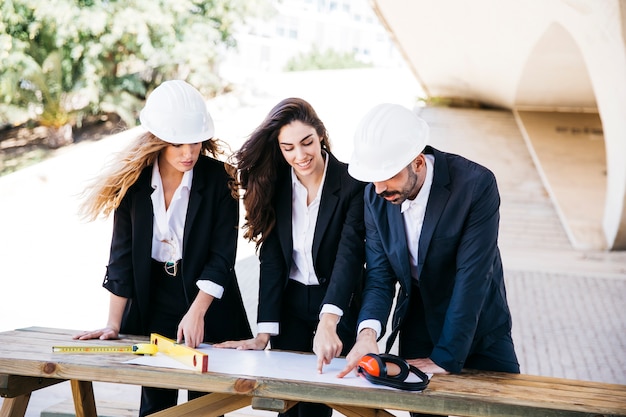 Three architects with plan on table