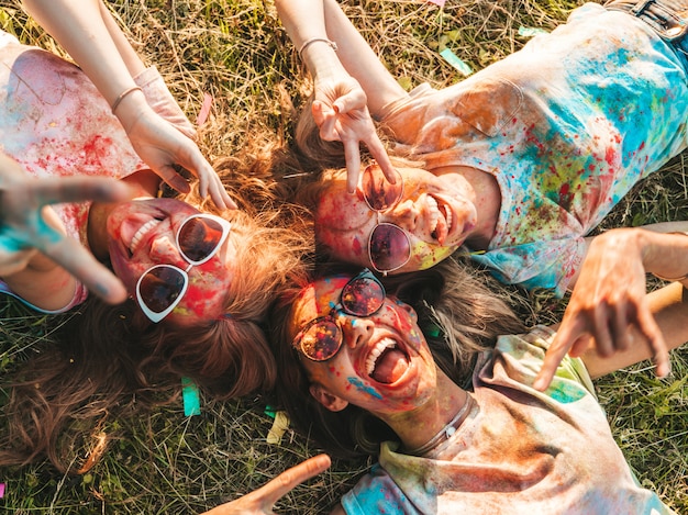 Three beautiful smiling girls posing at Holi party