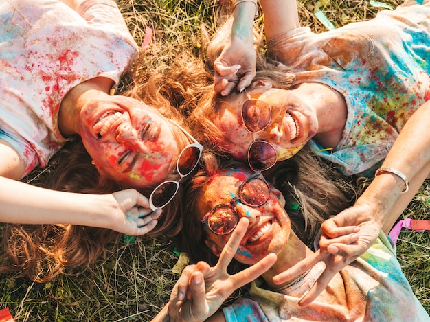 Three beautiful smiling girls posing at Holi party