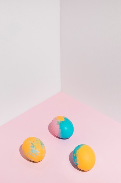 Free photo three bright easter eggs scattered on table