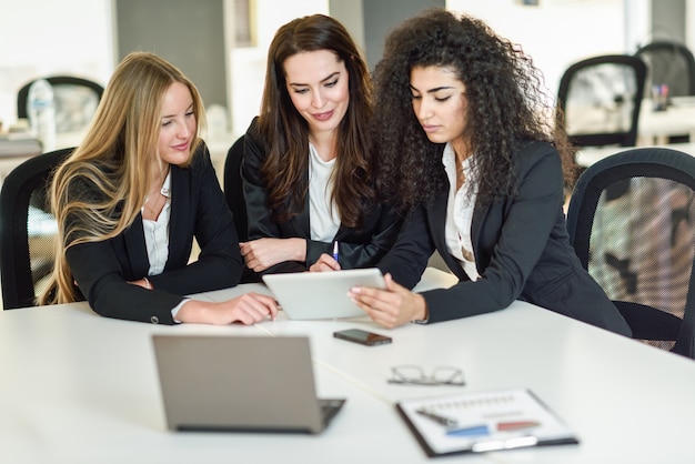 Three businesswomen working together in a modern office