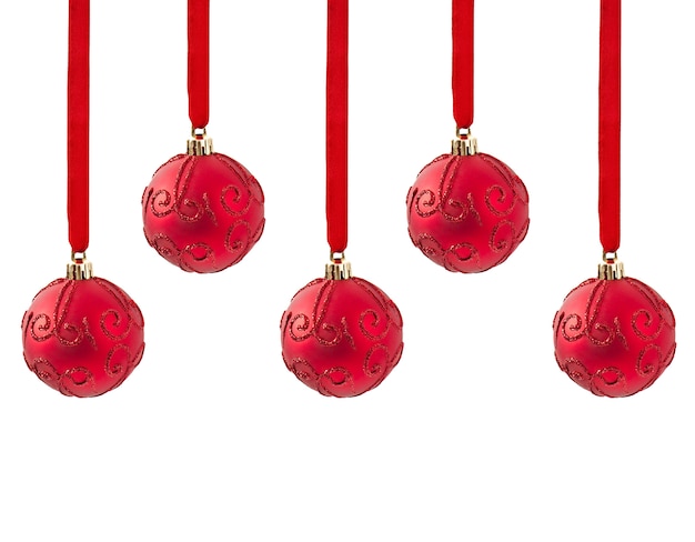 Three Christmas red balls hanging on ribbon isolated on white