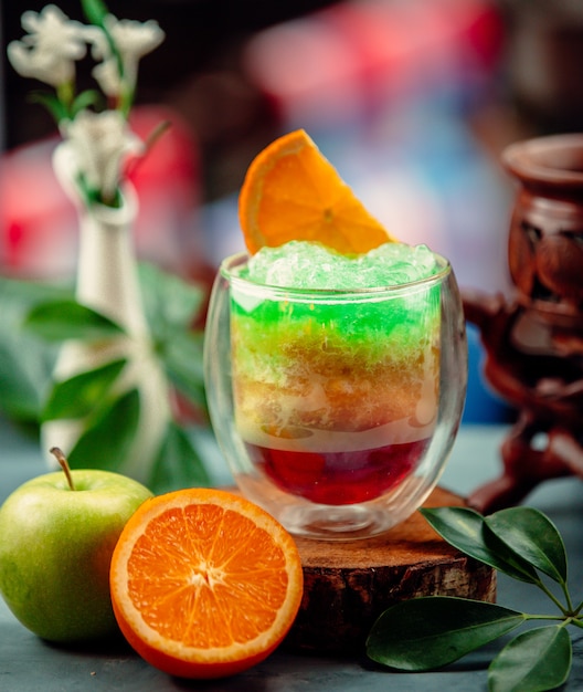 Free Photo three colors exotic cocktail with apple and orange juice and ice shaving