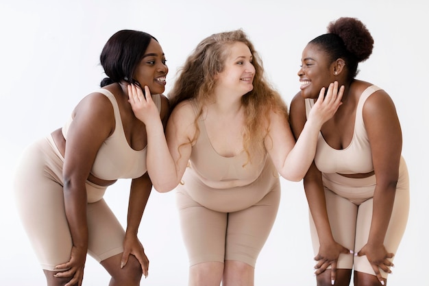 Free photo three confident women posing together while wearing a body shaper