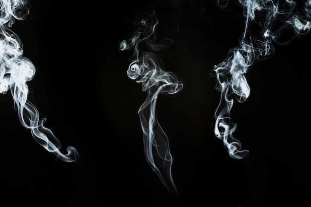 Three decorative silhouettes of white smoke