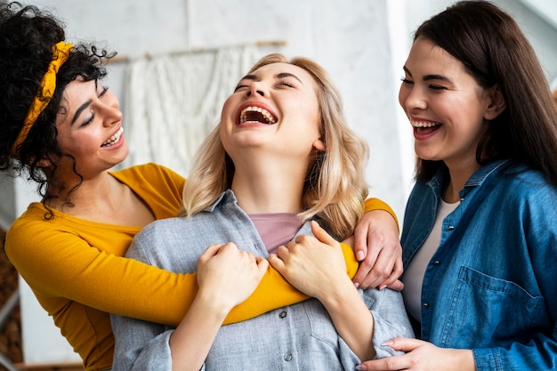 Free Photo three embraced women laughing together