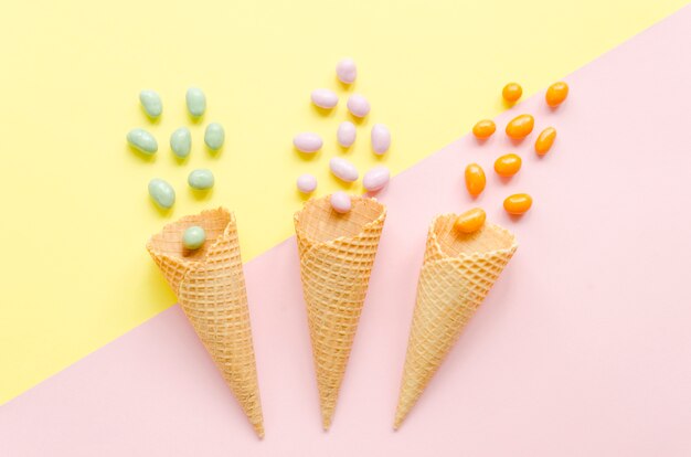 Three empty waffle cones with candies 