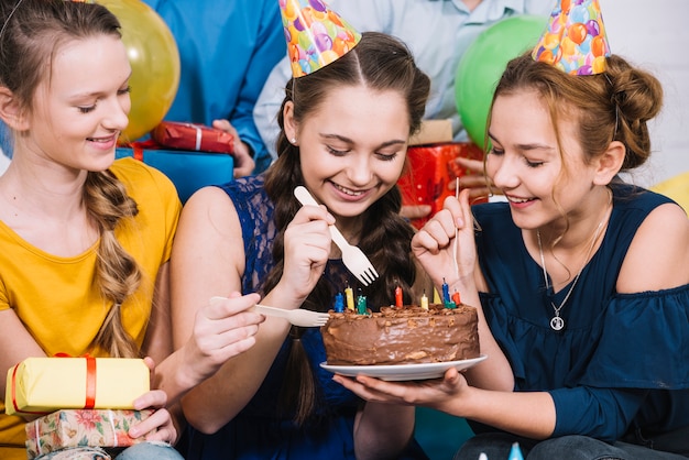 Free photo three female friends eating the cake with fork