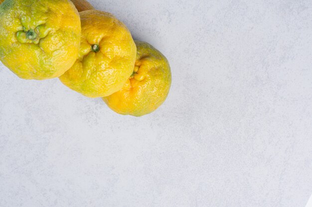 Three fresh organic tangerine on grey background. 