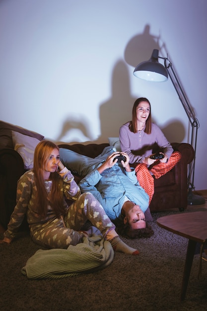 Free photo three friends playing on the console