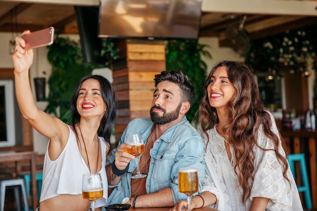 Three friends taking selfie in bar