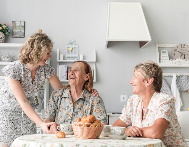 Free photo three generations of women having breakfast in kitchen