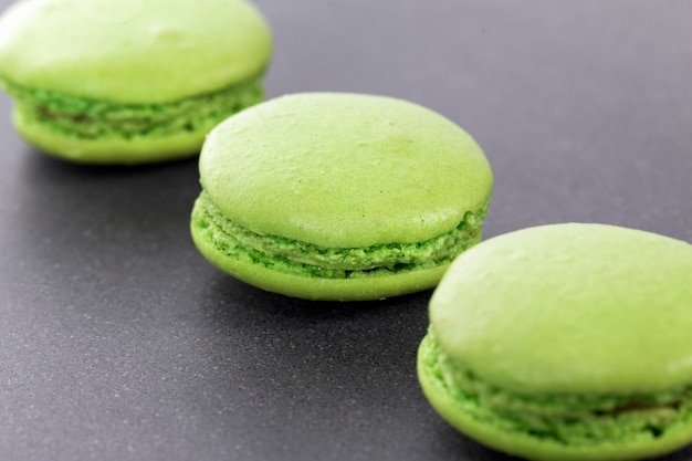 Free photo three green macaroons in kitchen