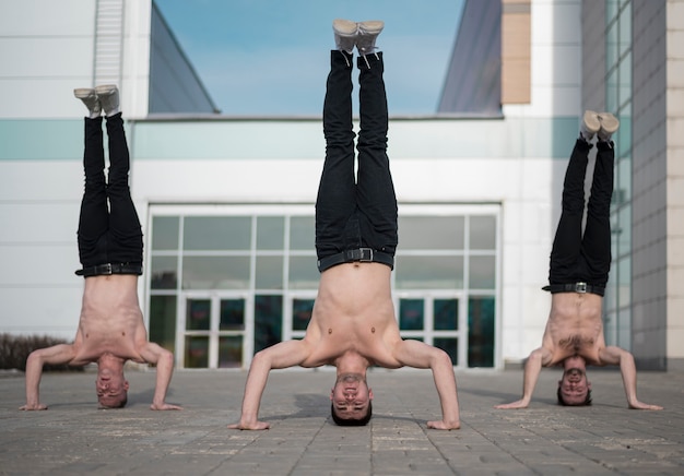 Free Photo three hip hop artists standing on their heads