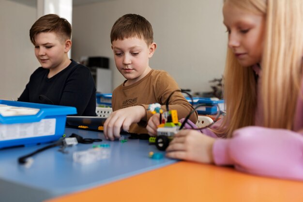 Three kids building a robot using electronic parts